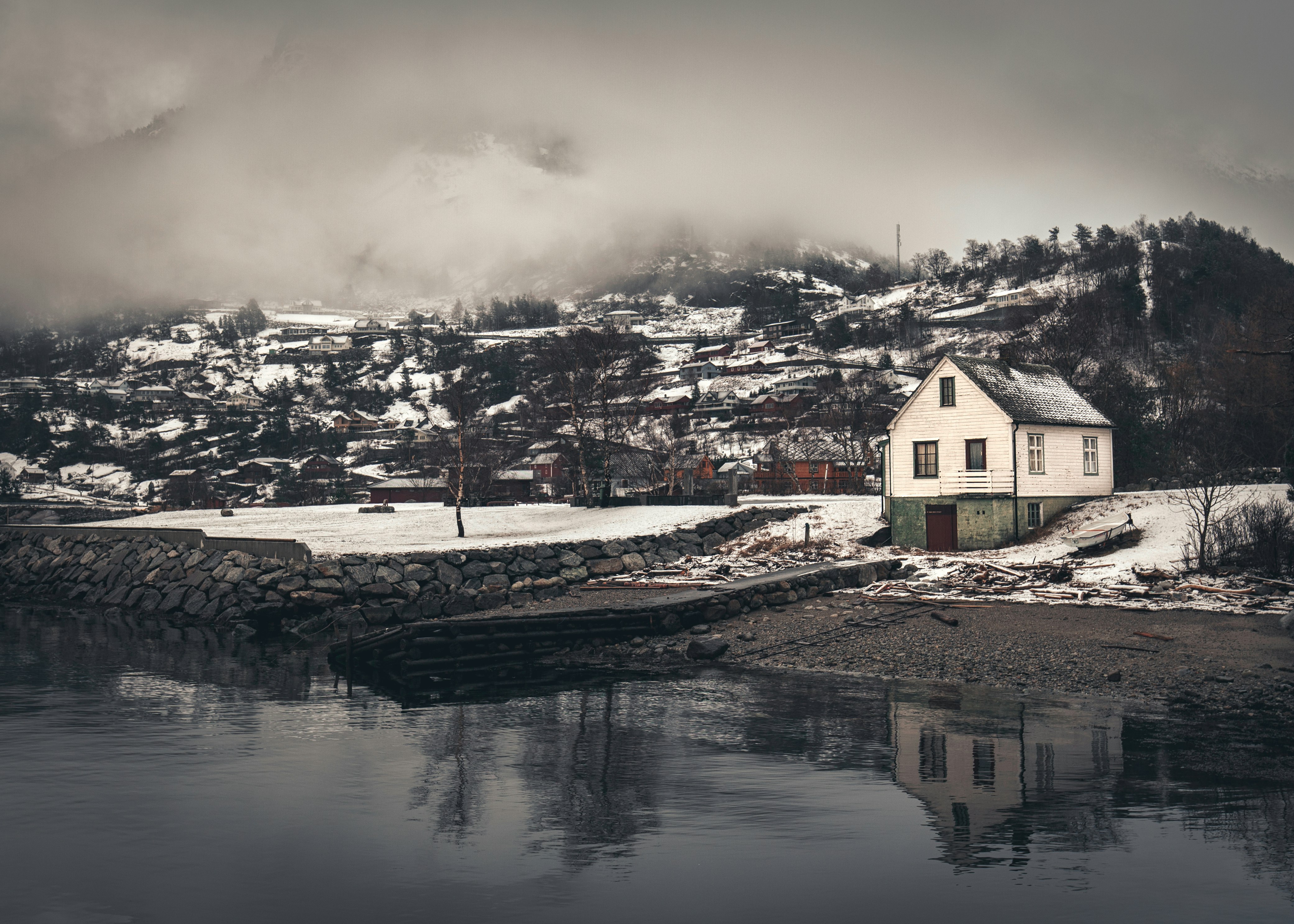 white and green house in front of lake